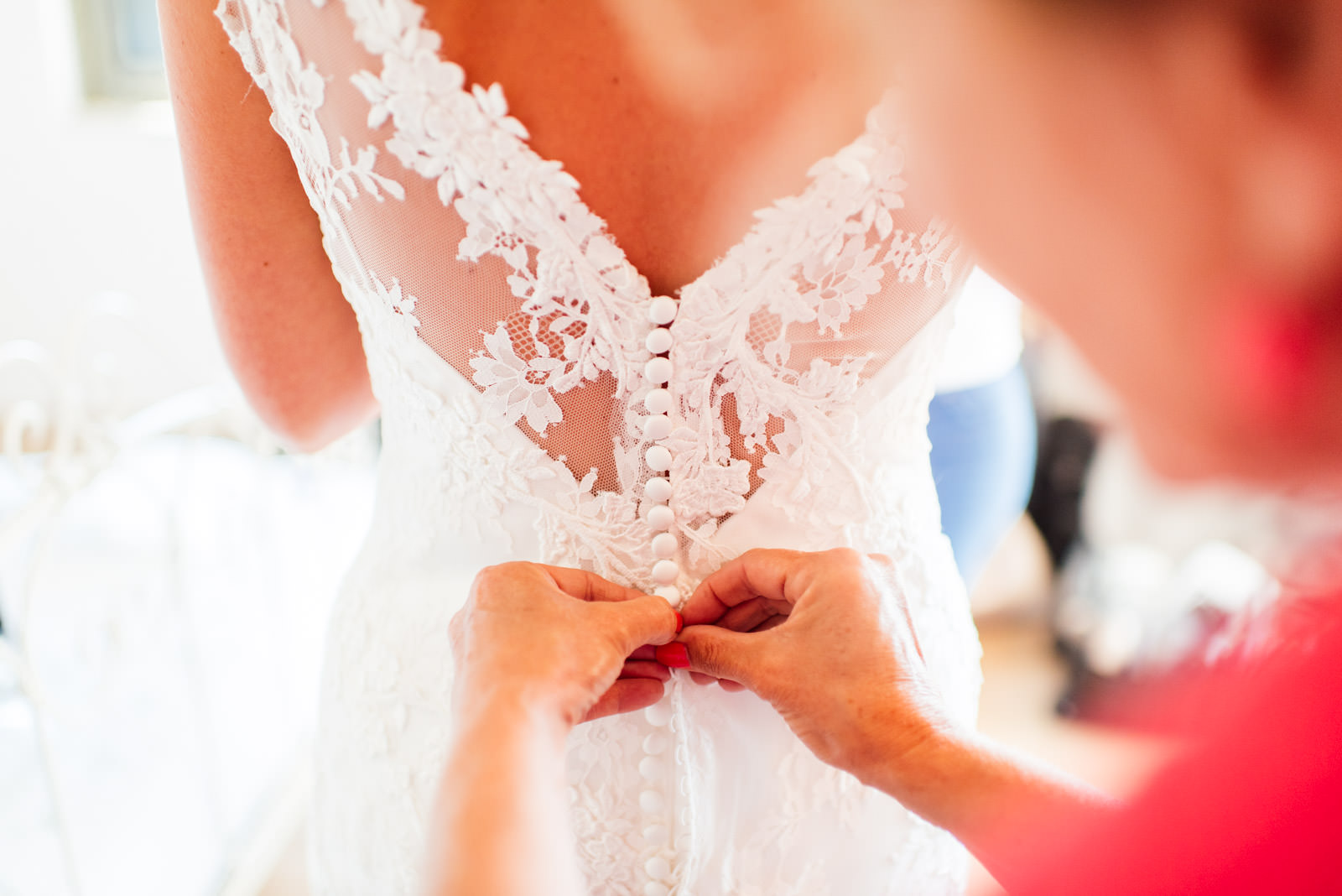 bride's dress being buttoned up