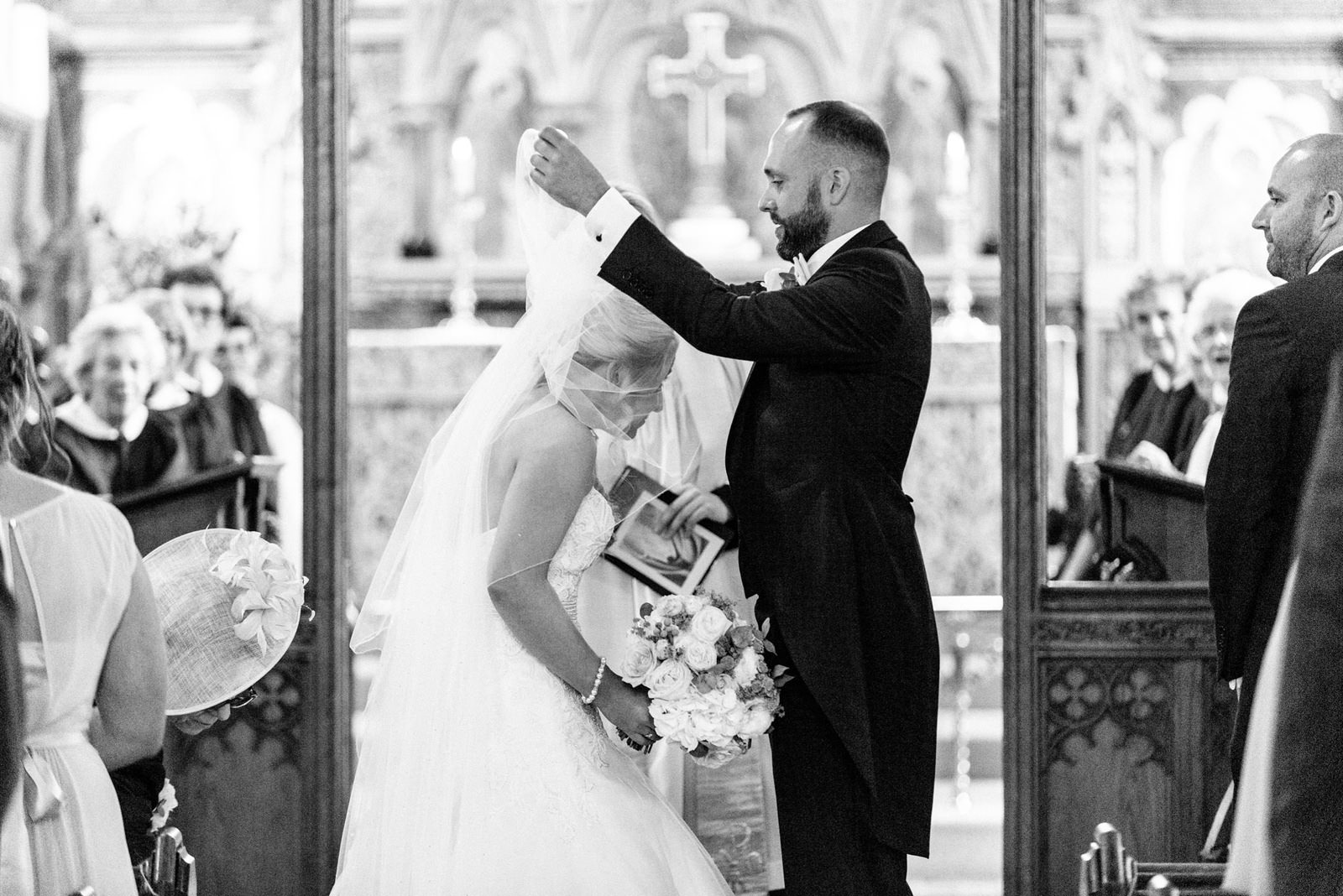 groom removing bride's veil