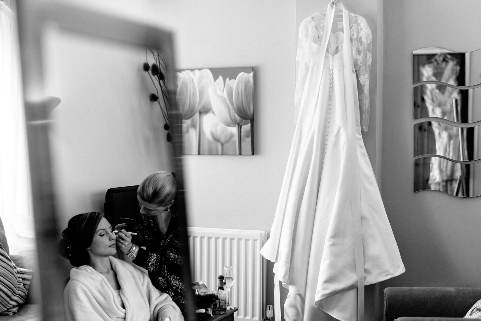 Photo of wedding dress and bride having make-up done