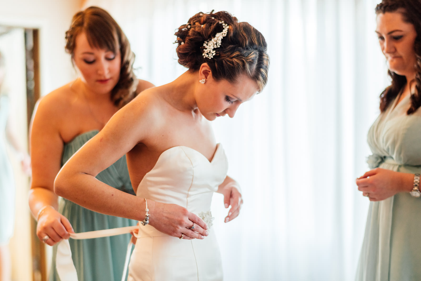 bride putting on wedding dress