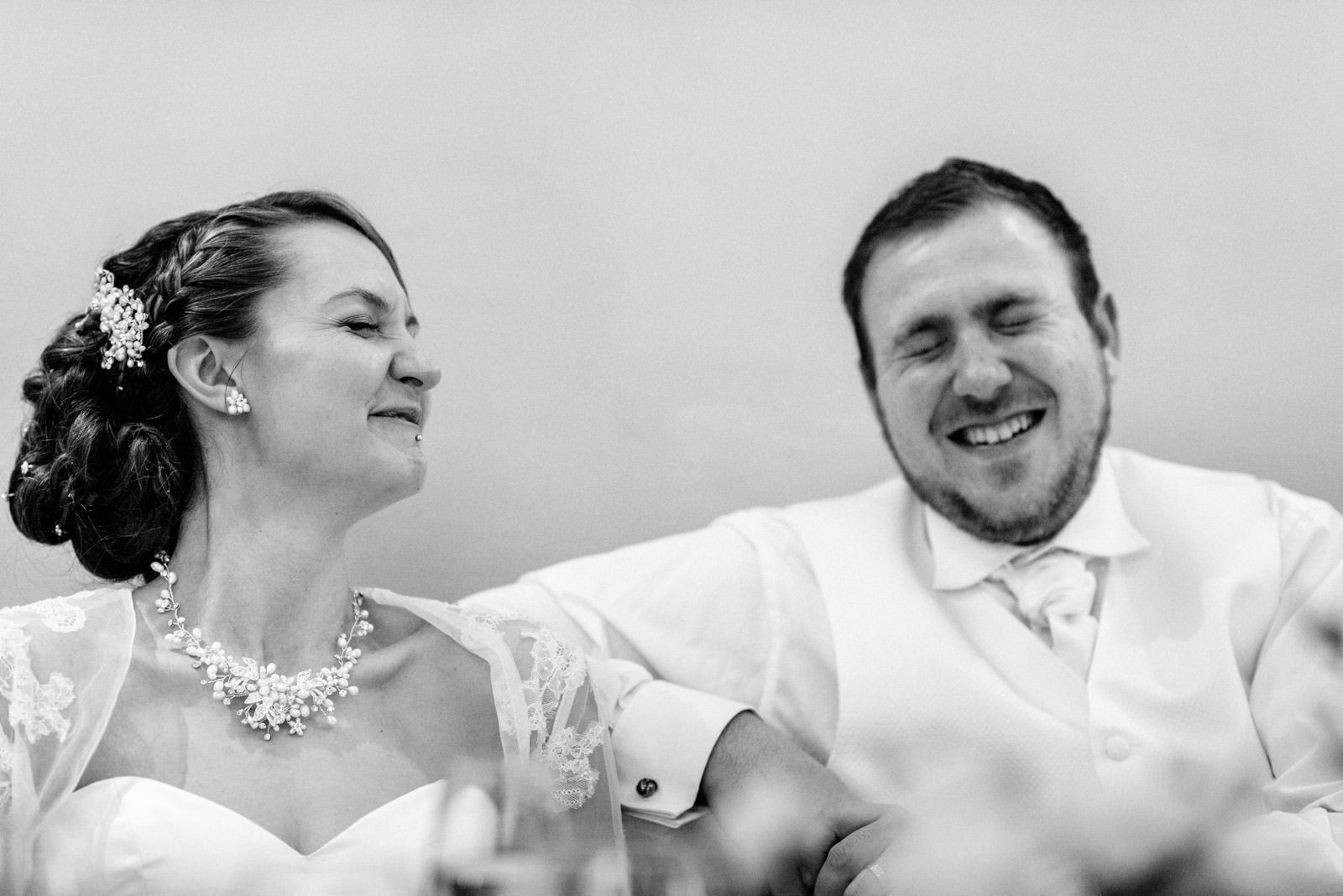 bride and groom laughing to speeches