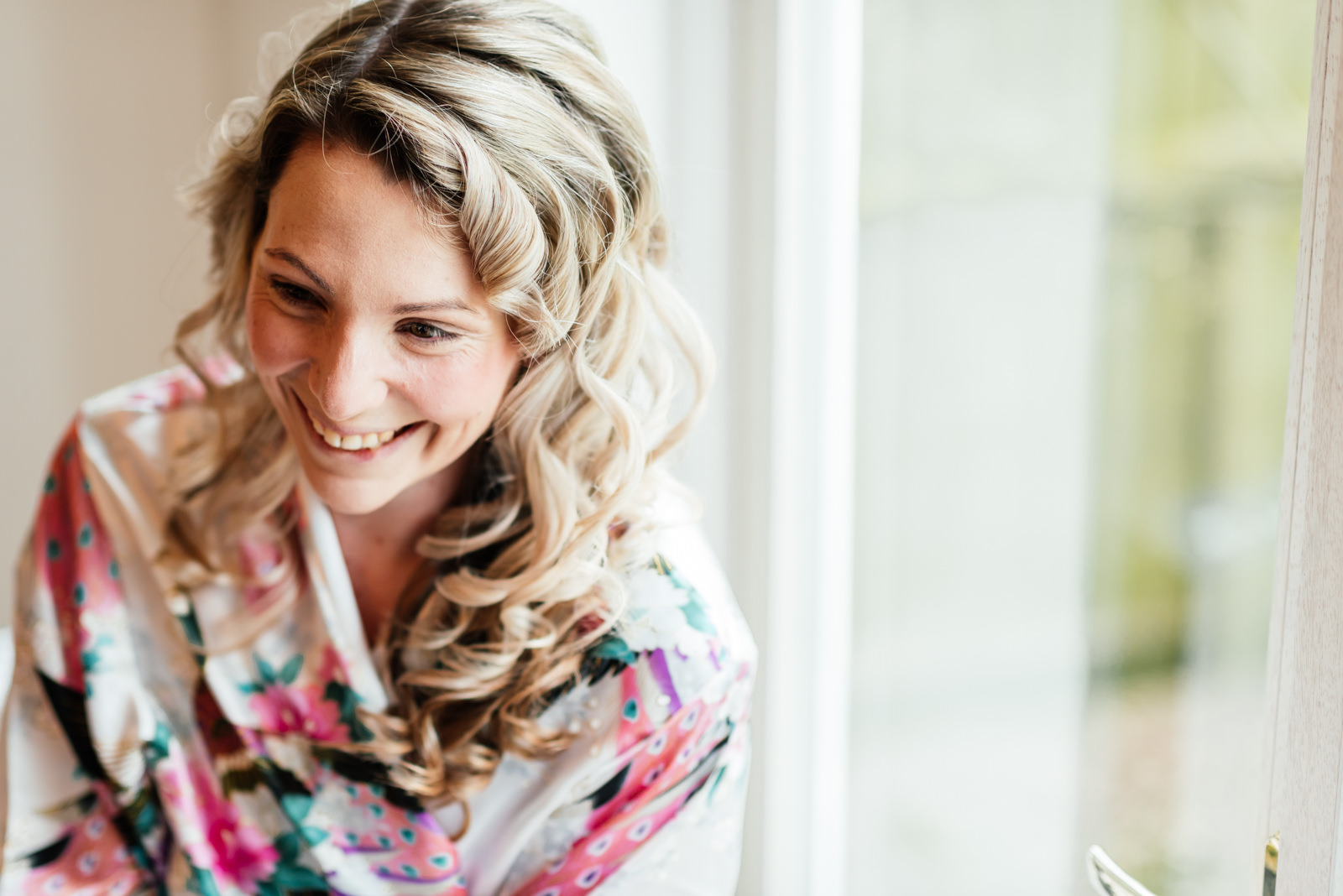 bride smiling during make-up for wedding