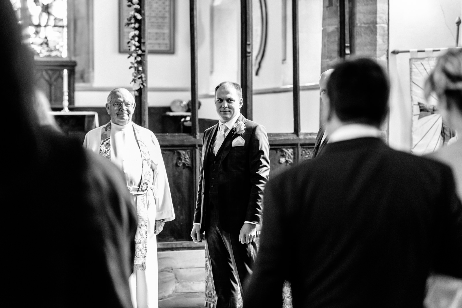 groom watching as bride walks down the aisle