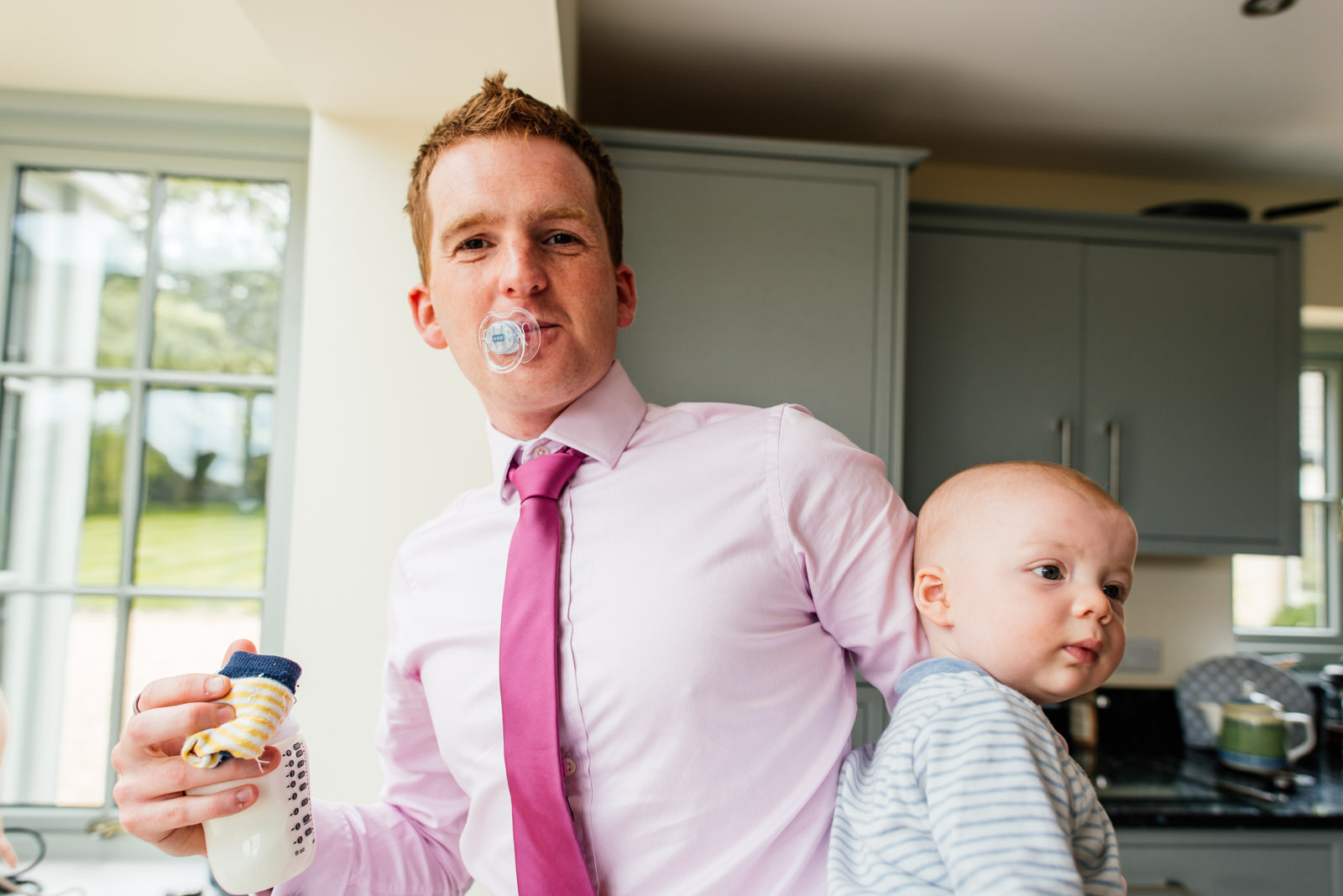 family member with dummy in mouth holding baby