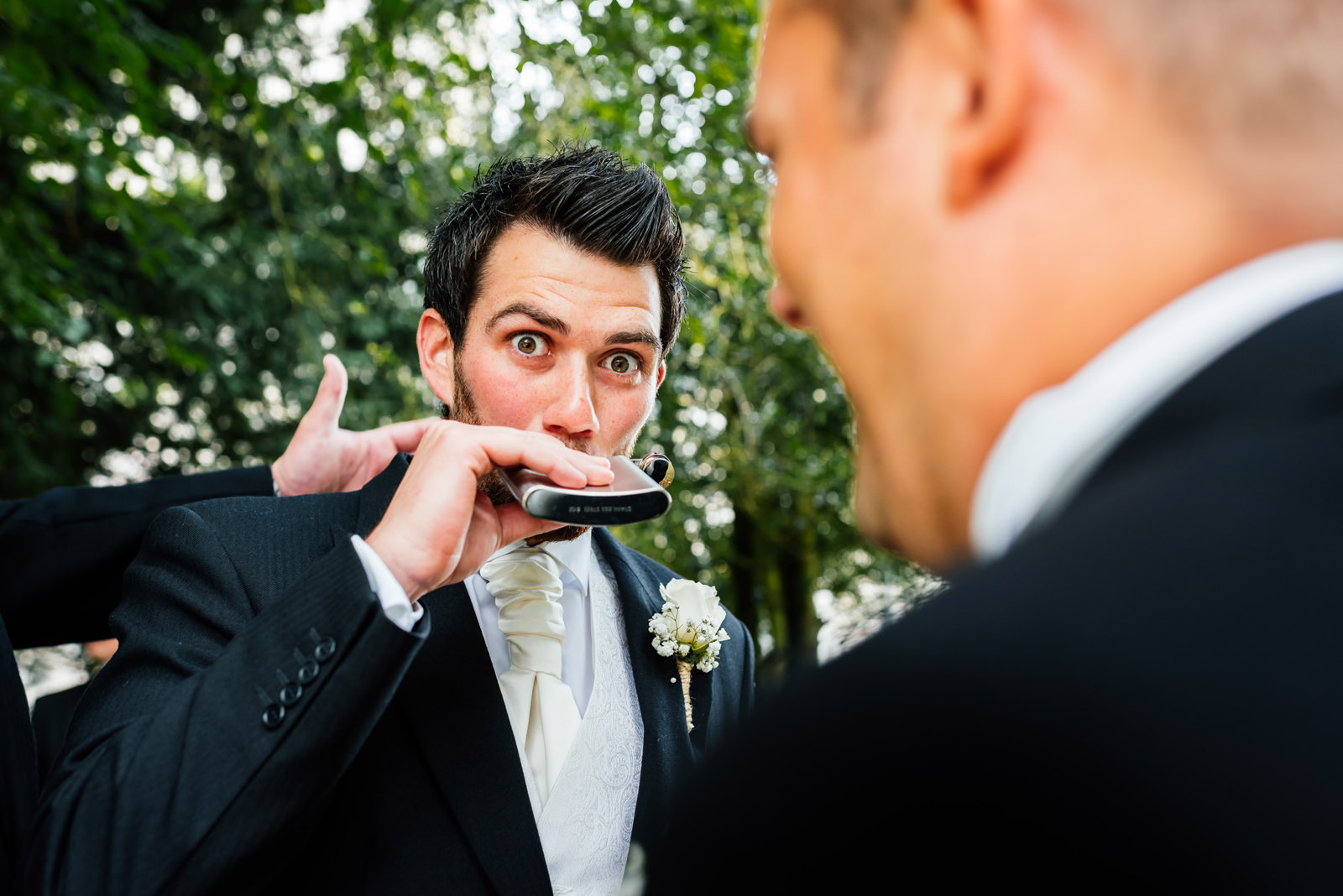 groom has a quick swig of alcohol before ceremony