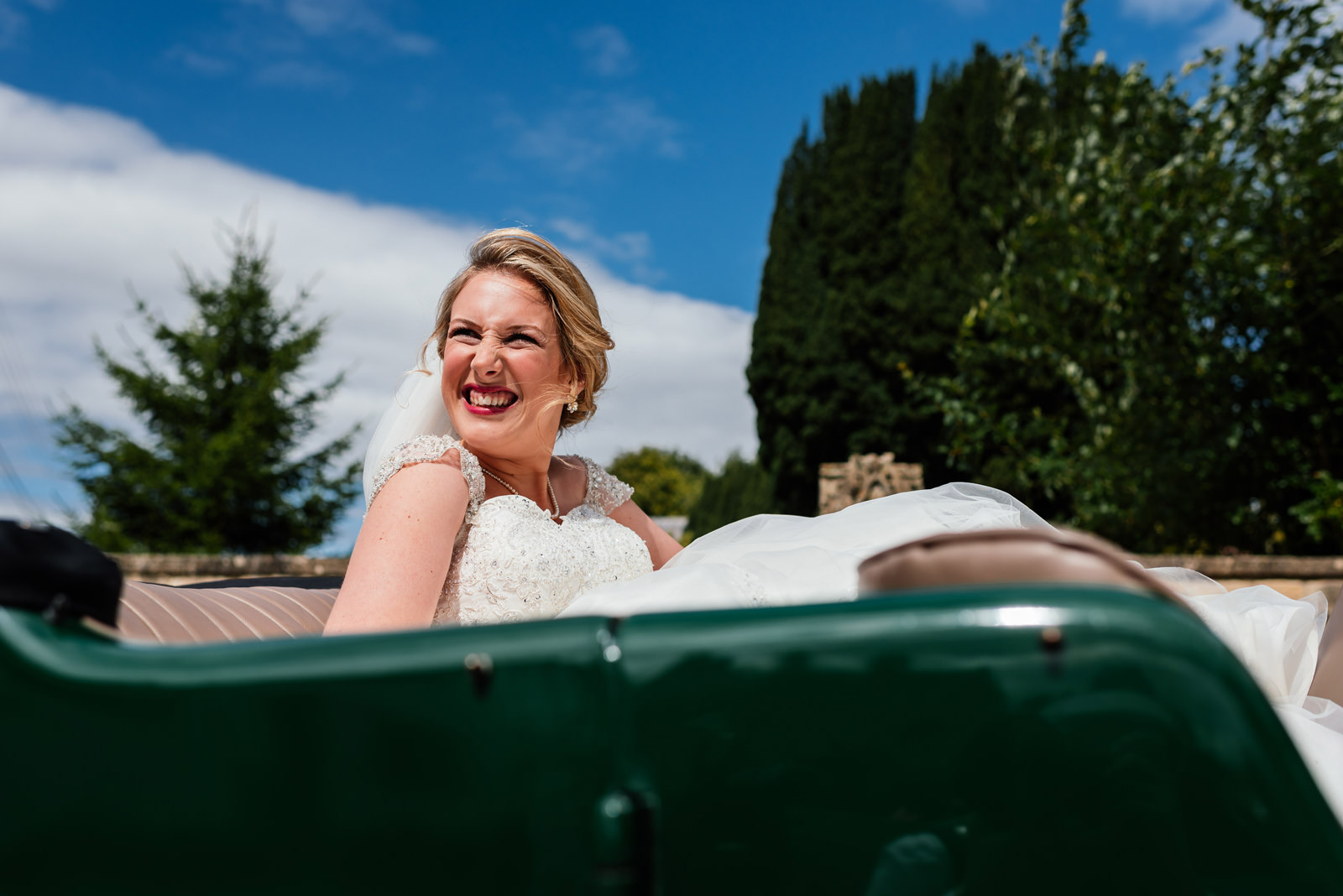 bride in the sunshine in vintage green car