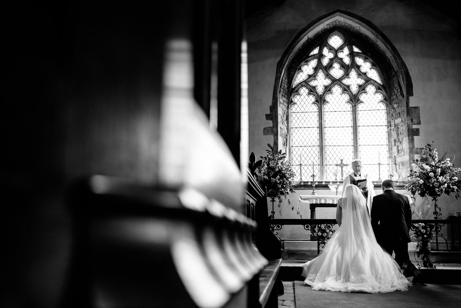 bride and groom receiving blessing during church ceremony