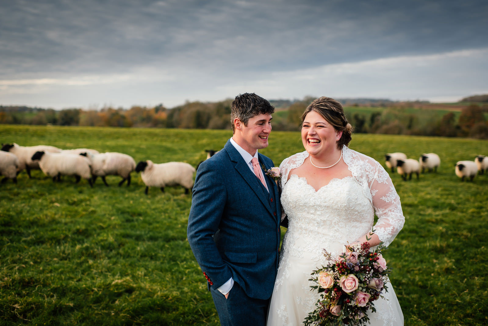 bride and groom in a field of sheep
