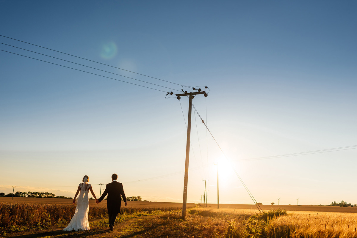 bride and groom walking off into the sunset