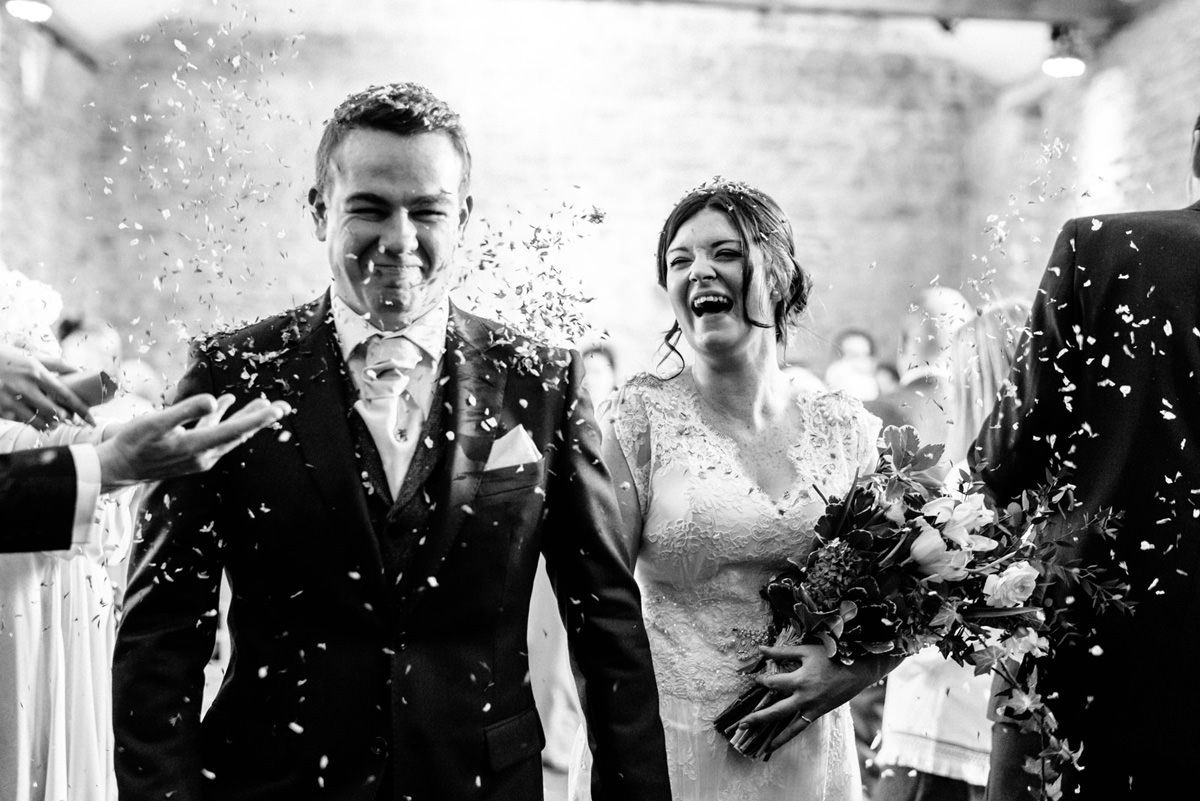 bride laughing during confetti walk through