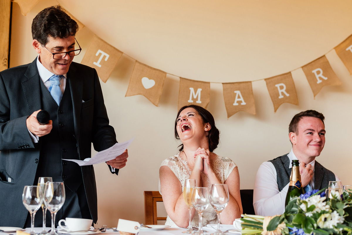 bride laughing at father of the bride speech