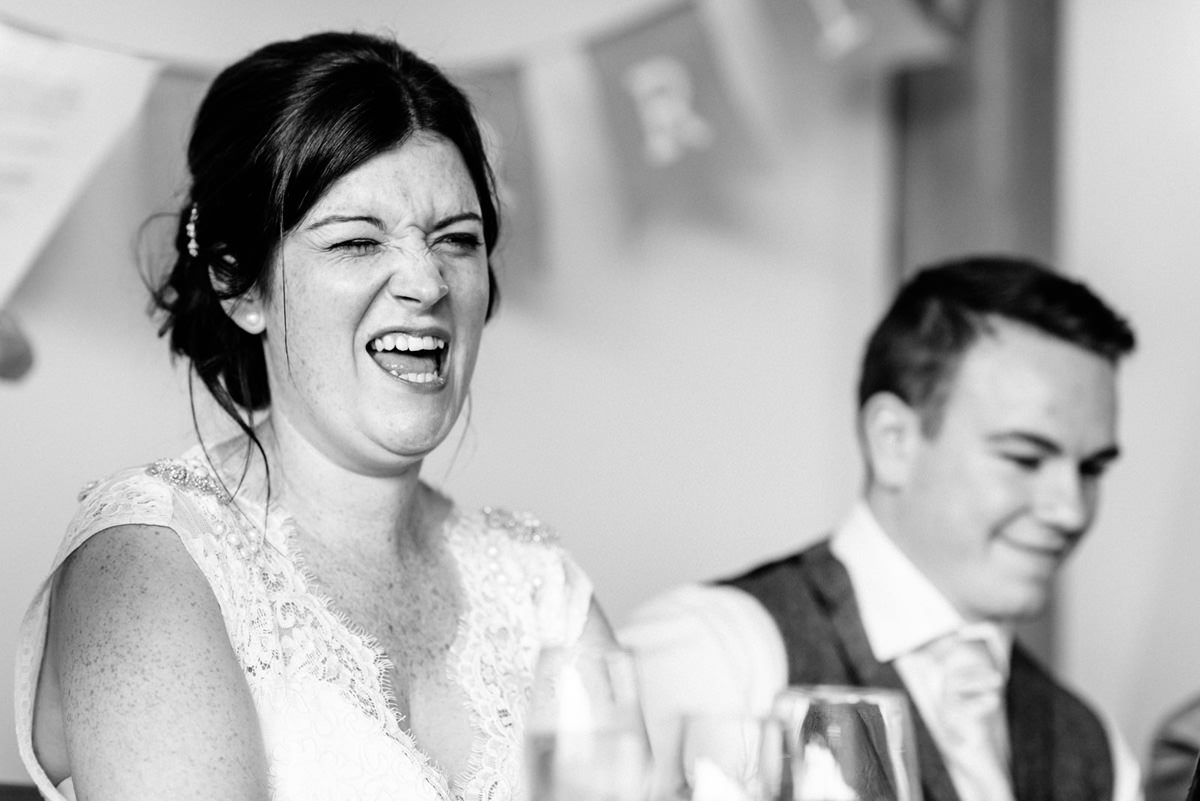 bride pulling funny face during wedding speeches 