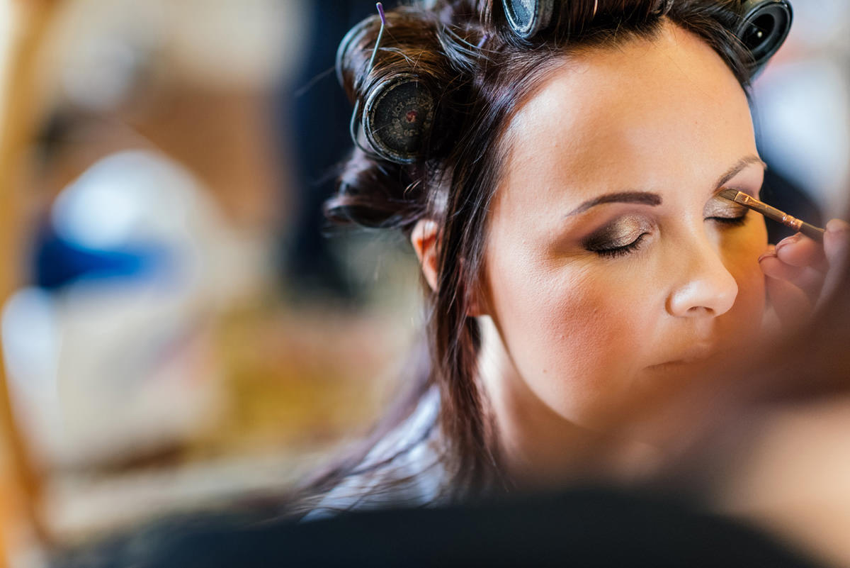 Bride having make up done on the morning of wedding day