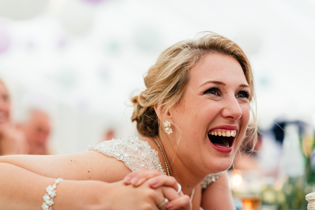 bride laughing during the speeches
