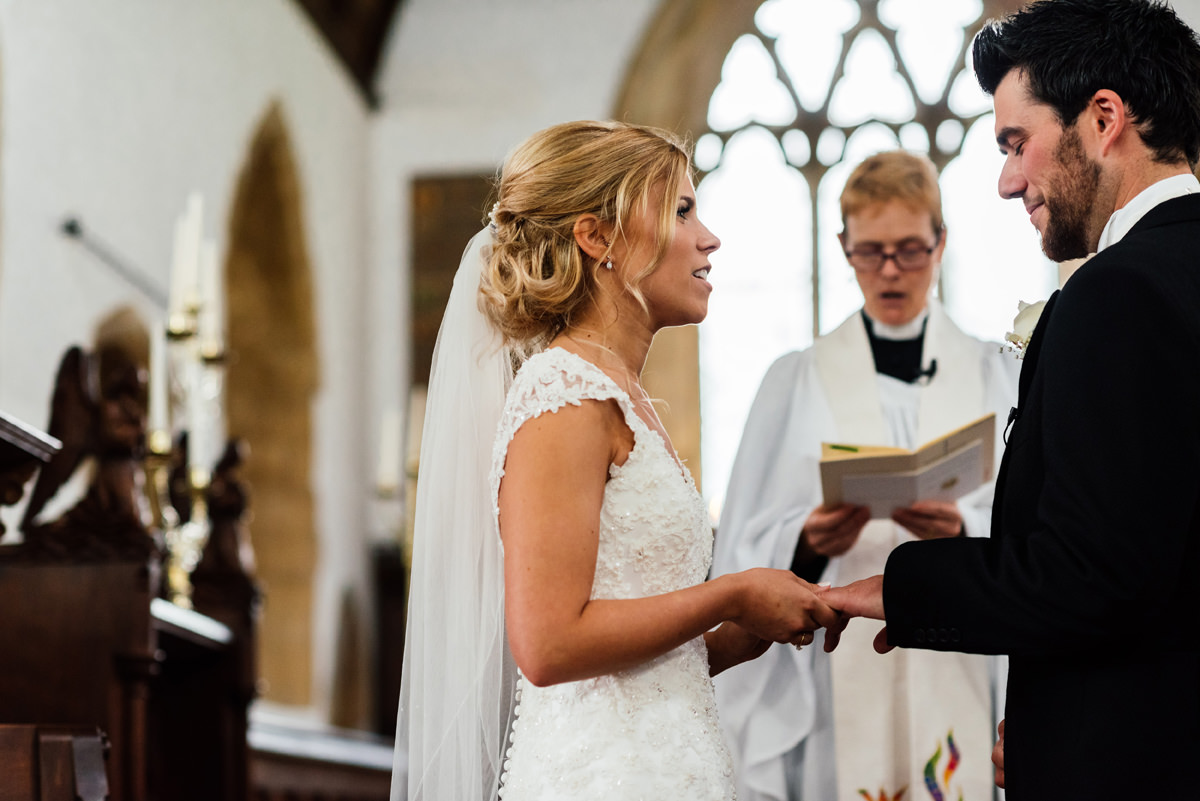 bride and groom exchanging vows in church ceremony