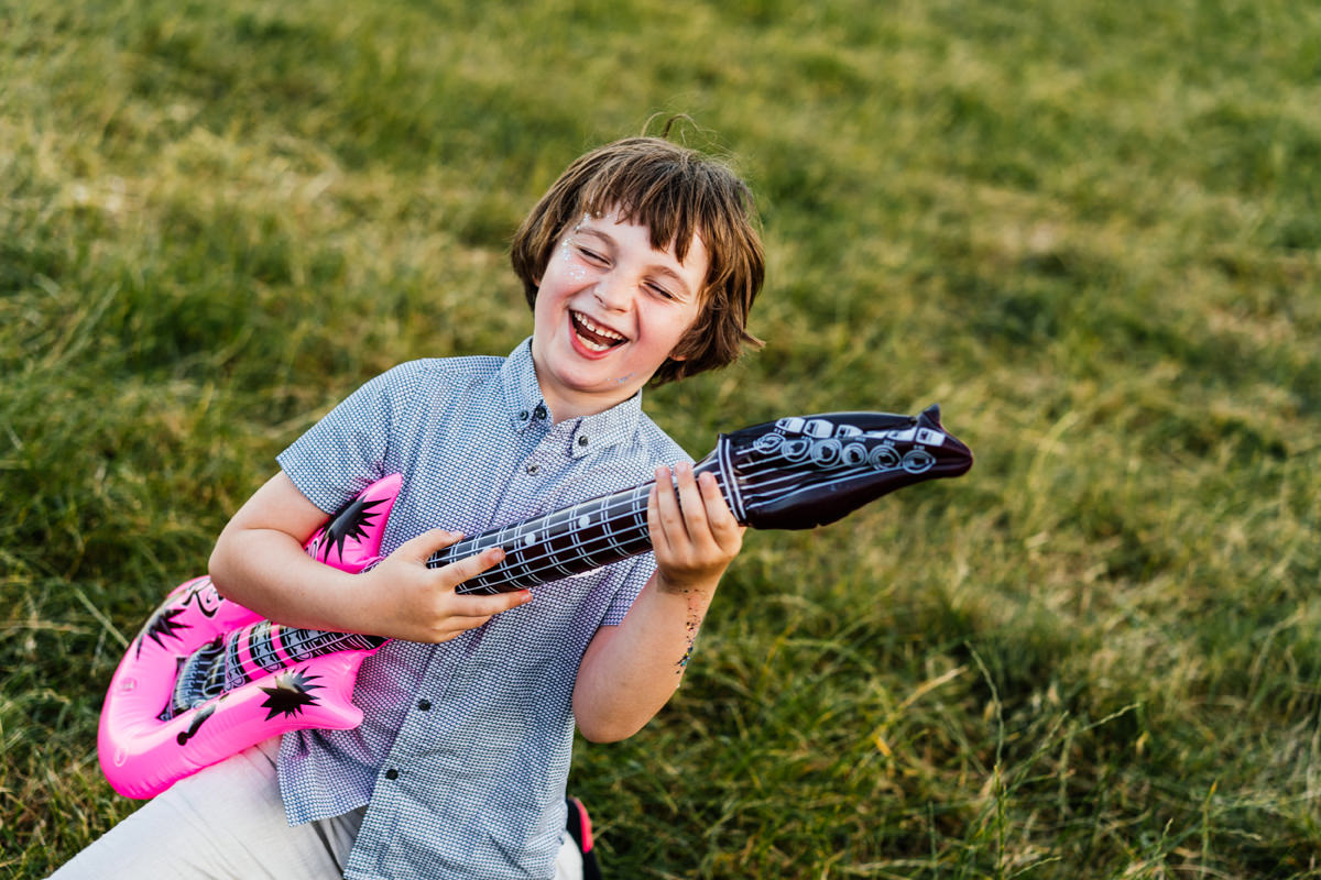child at wedding rocking out with inflatable guitar