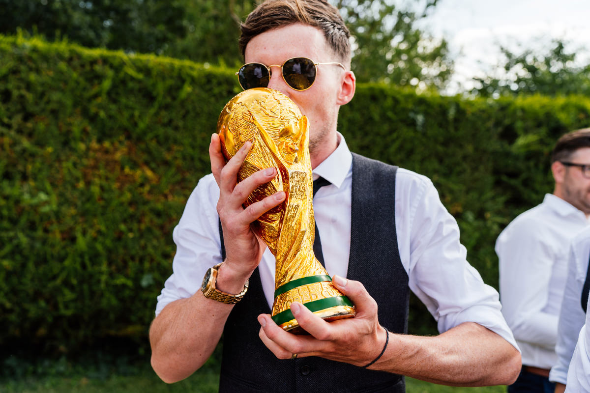 groom kisses the FIFA world cup trophy