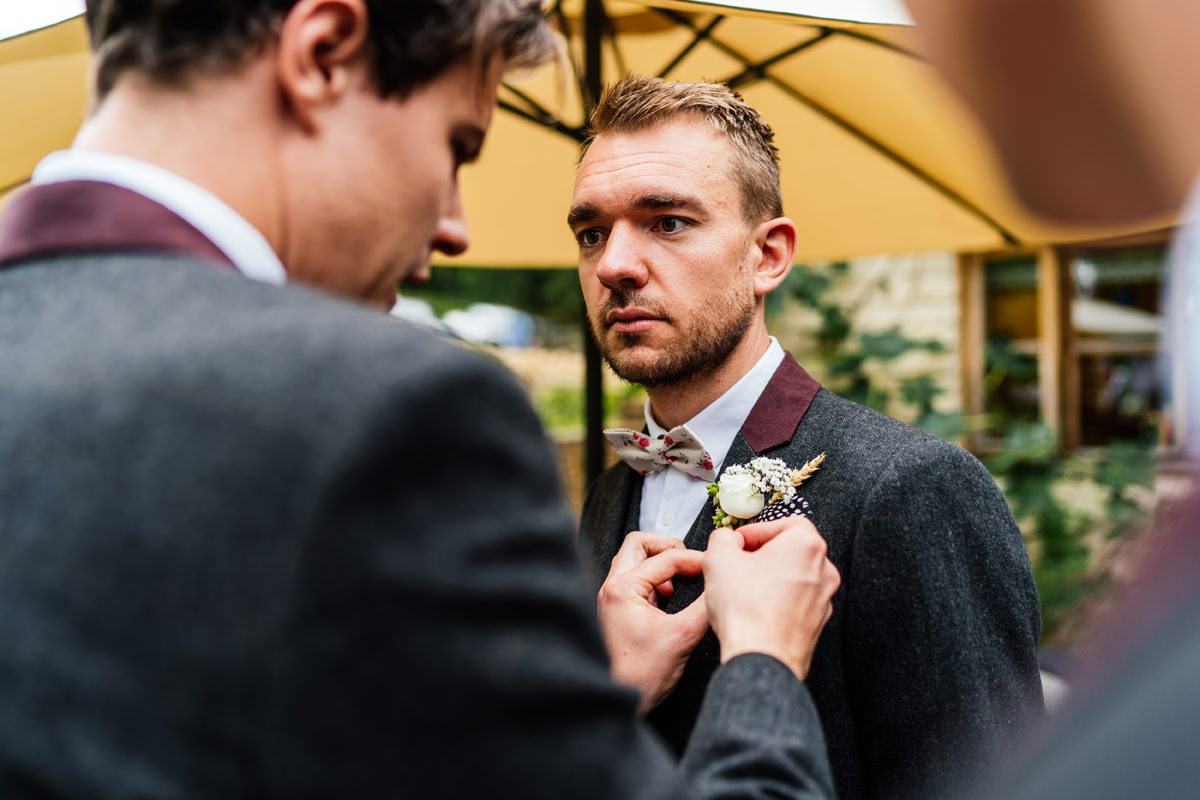 groom having his button hole put on