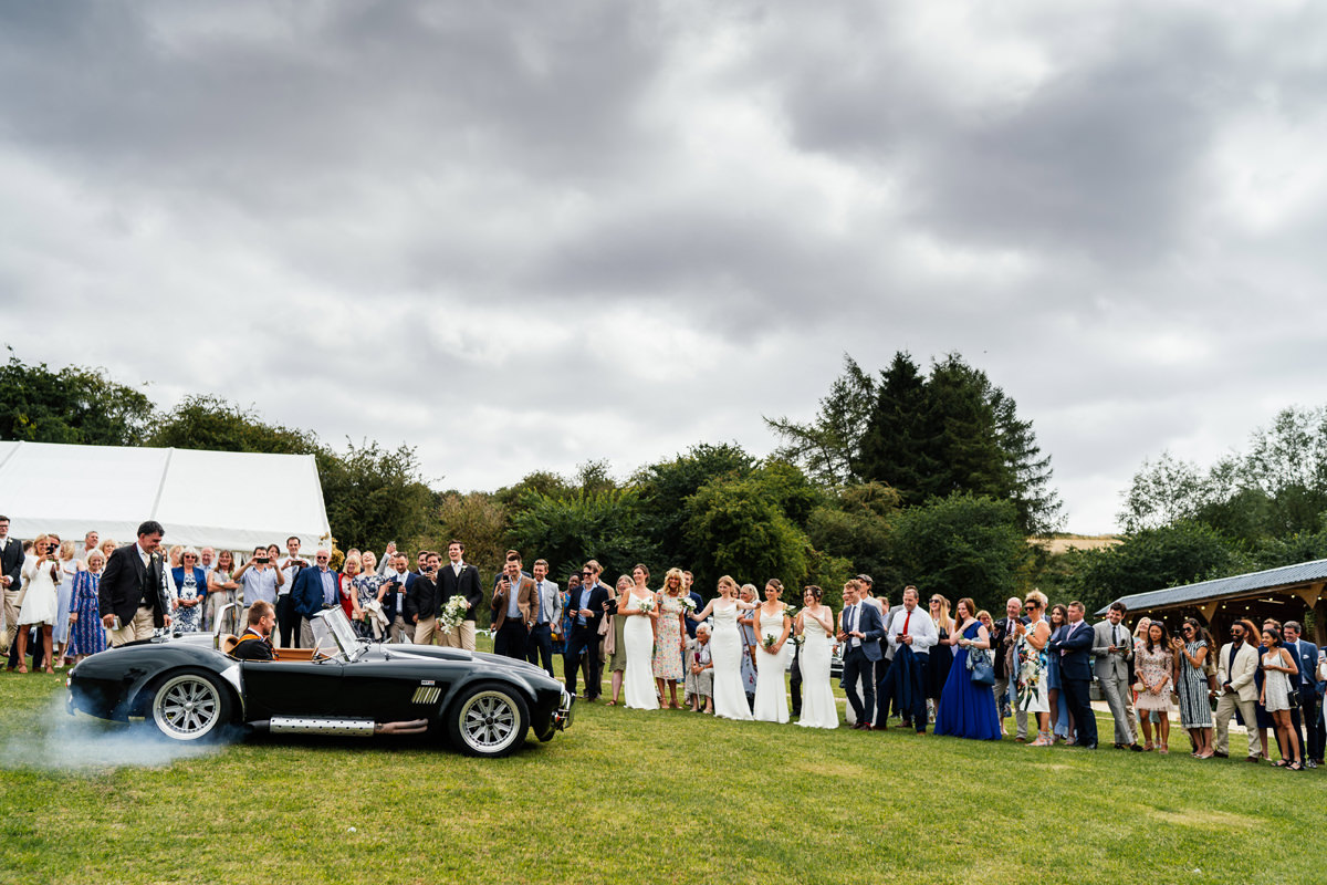 groom drives off the bride in his sports car