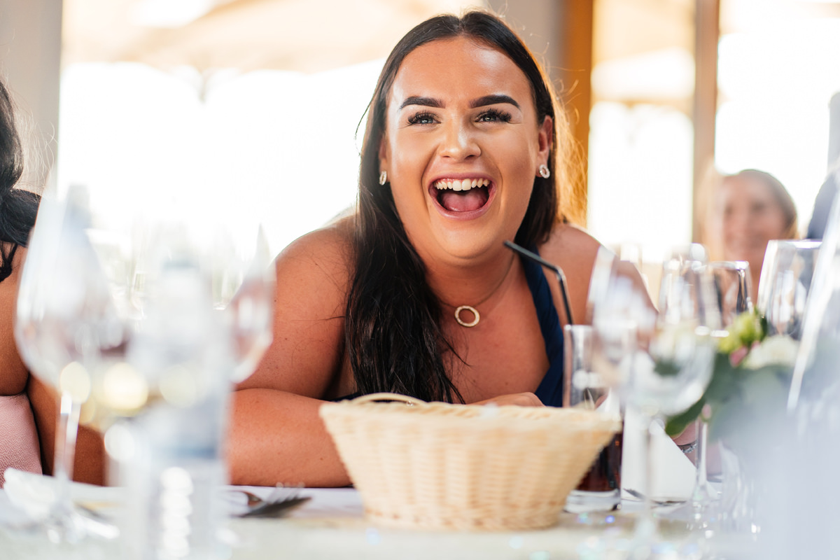 wedding guest laughing during wedding speeches
