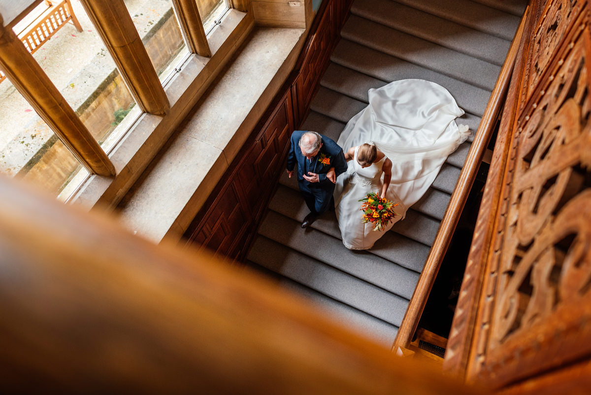 bride and father walk down the stairs to go to the ceremony