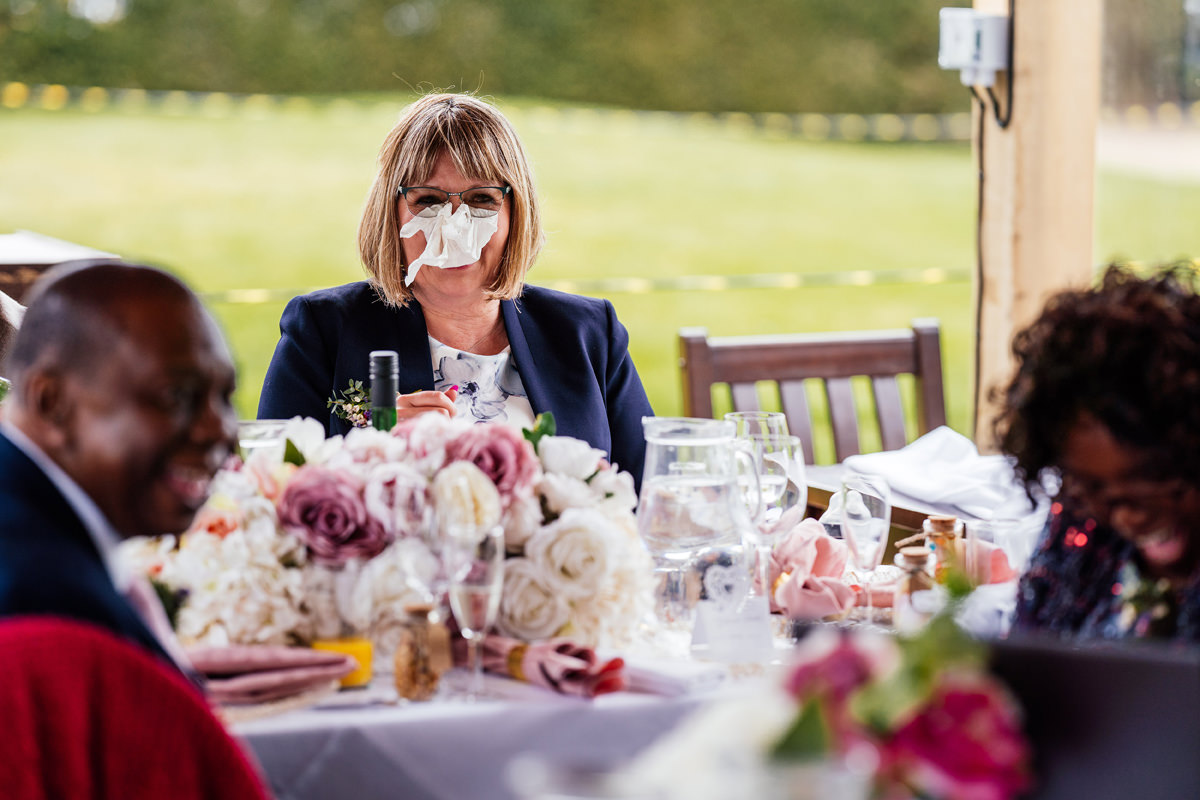 wedding guest with tissue stuffed up her nose