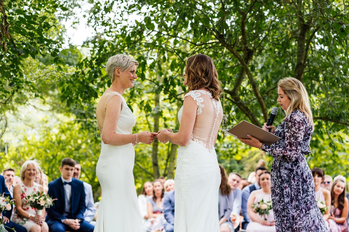 Brides exchanging rings during ceremony