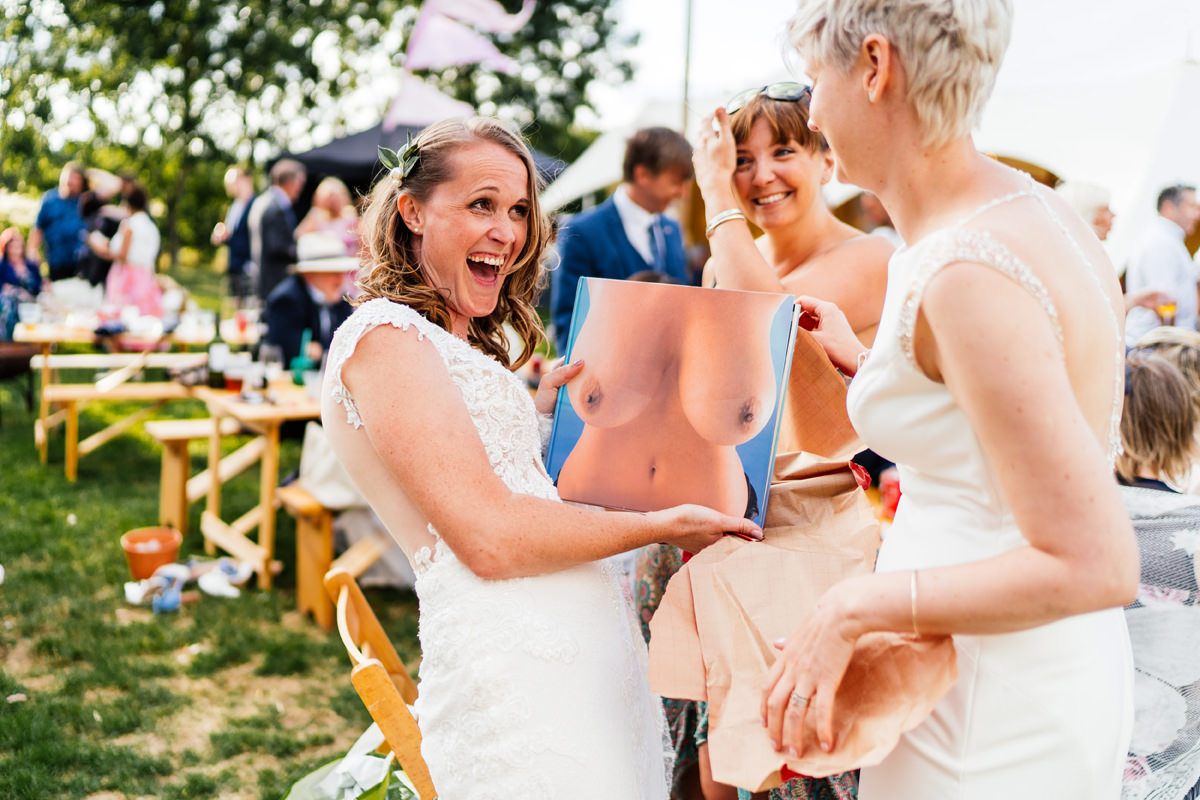 Brides laughing at the book of boobs