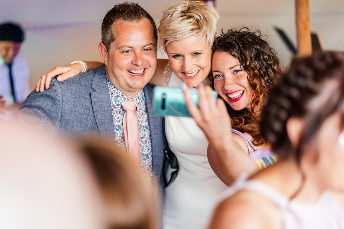 bride and friends doing a selfie on the dance floor