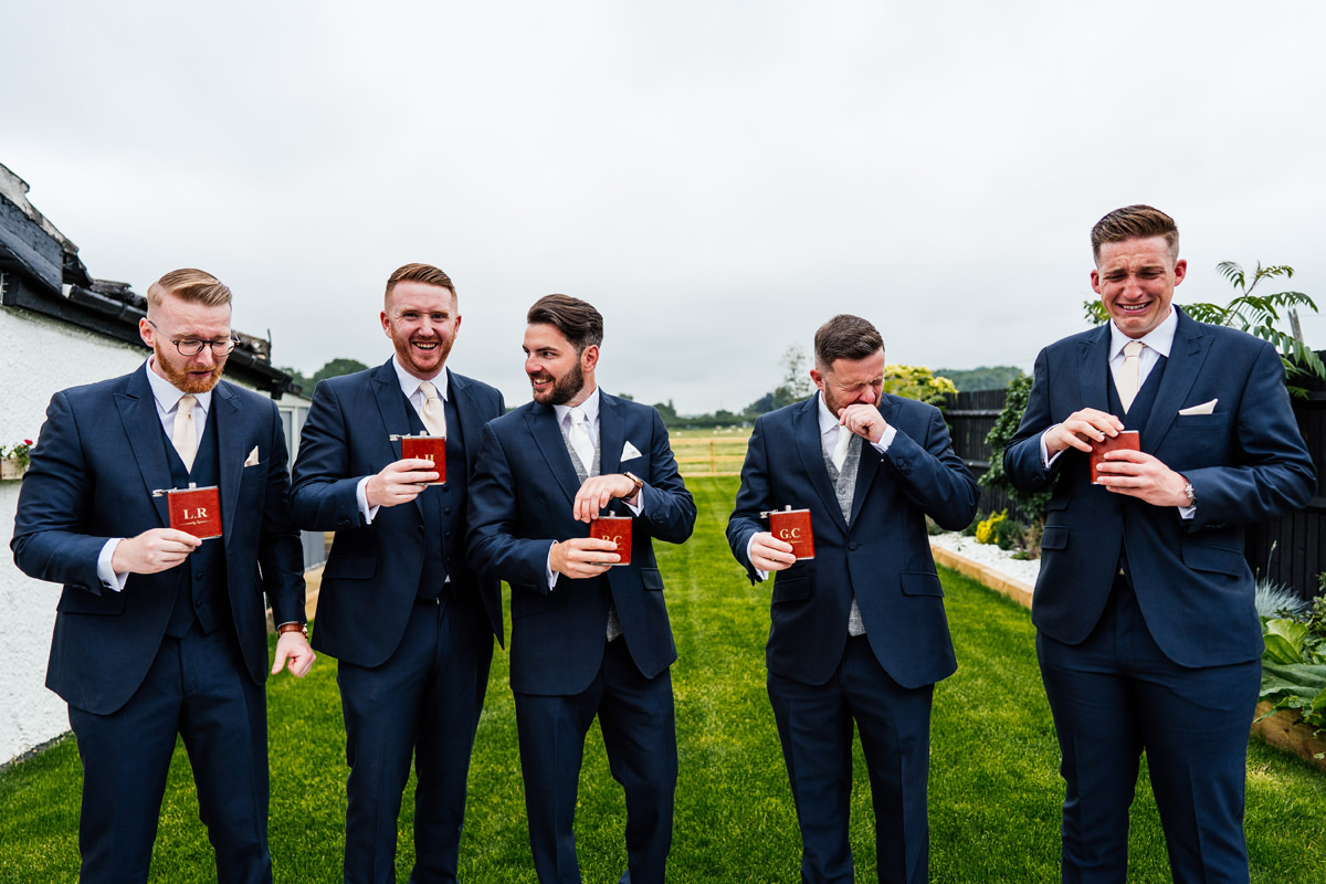 Groom and his groomsmen having a shot of whiskey before the wedding