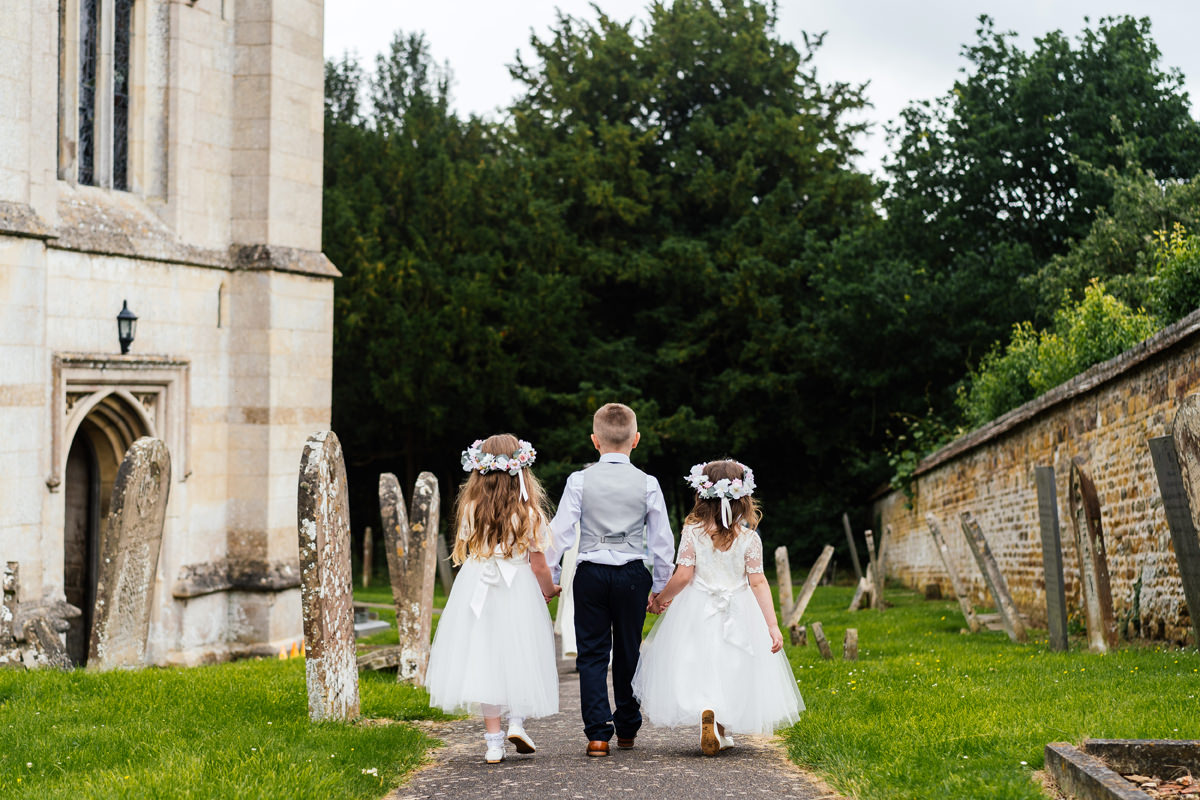 Page boy and flower girls lead the way to the church