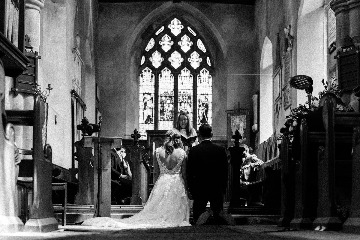 bride and groom kneeling during the prayers