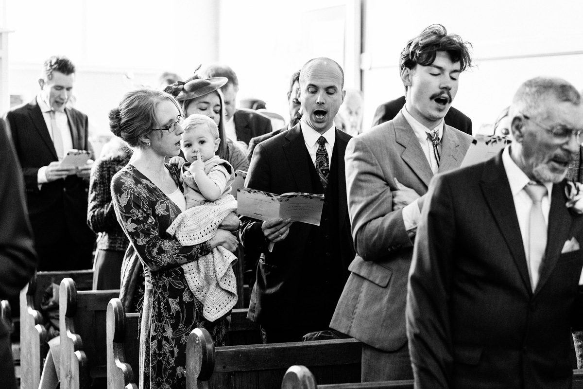 wedding guests singing in the church ceremony