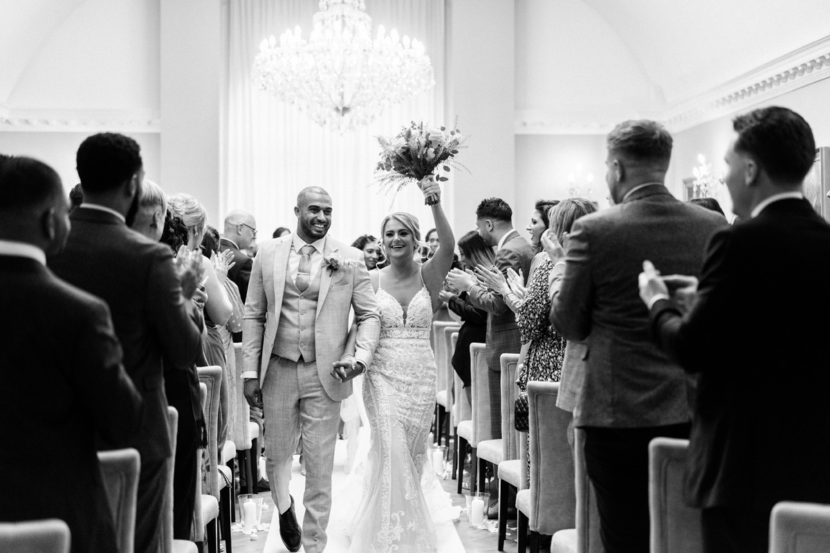 bride holding her bouquet up high as she walks down the aisle at the end of the ceremony