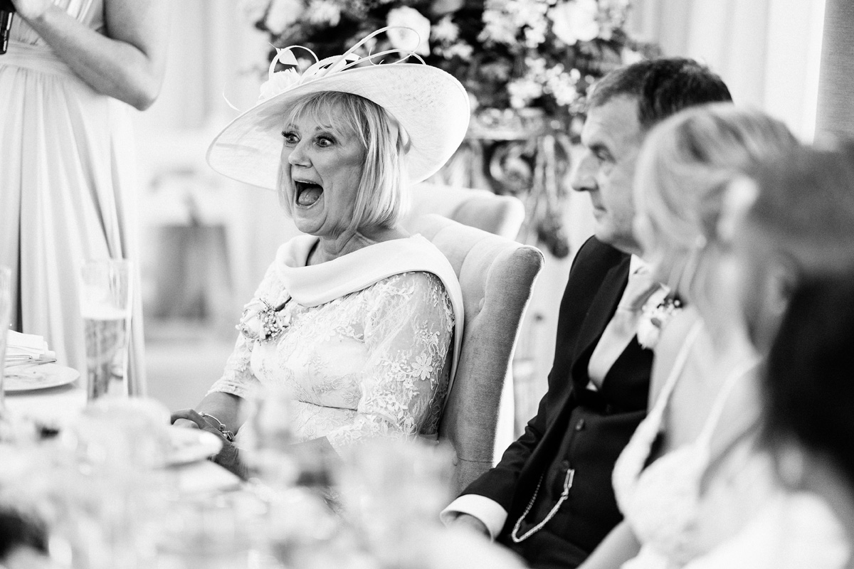 mum of the bride laughing during the speeches