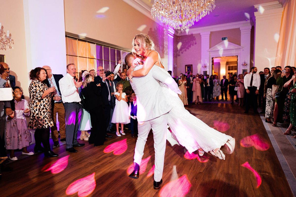 Groom picks up his bride during the first dance