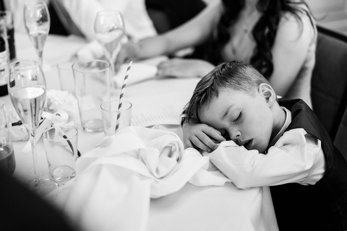 young boy asleep on the table after listening to the speeches
