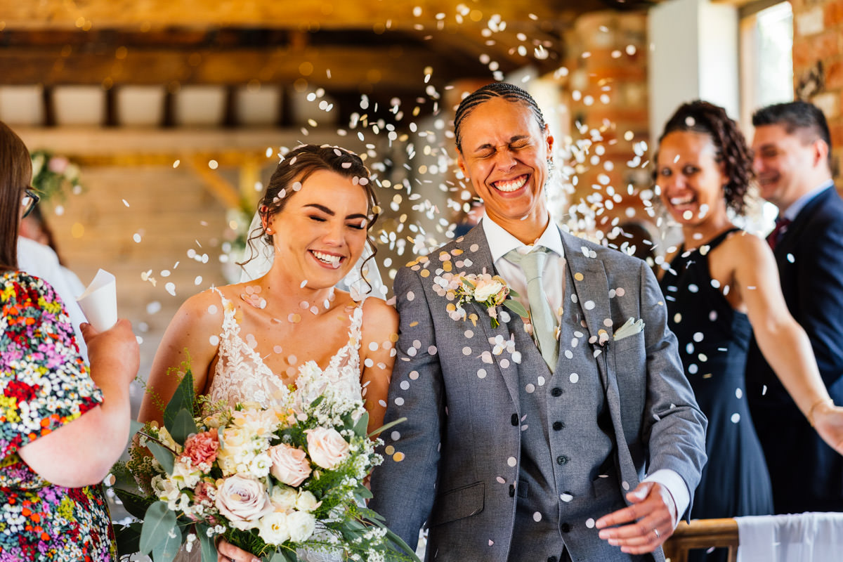 brides showered with confetti after the ceremony