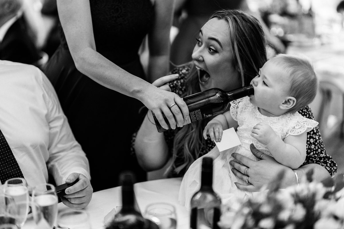 daughter of the bride drinking out of the wine bottle