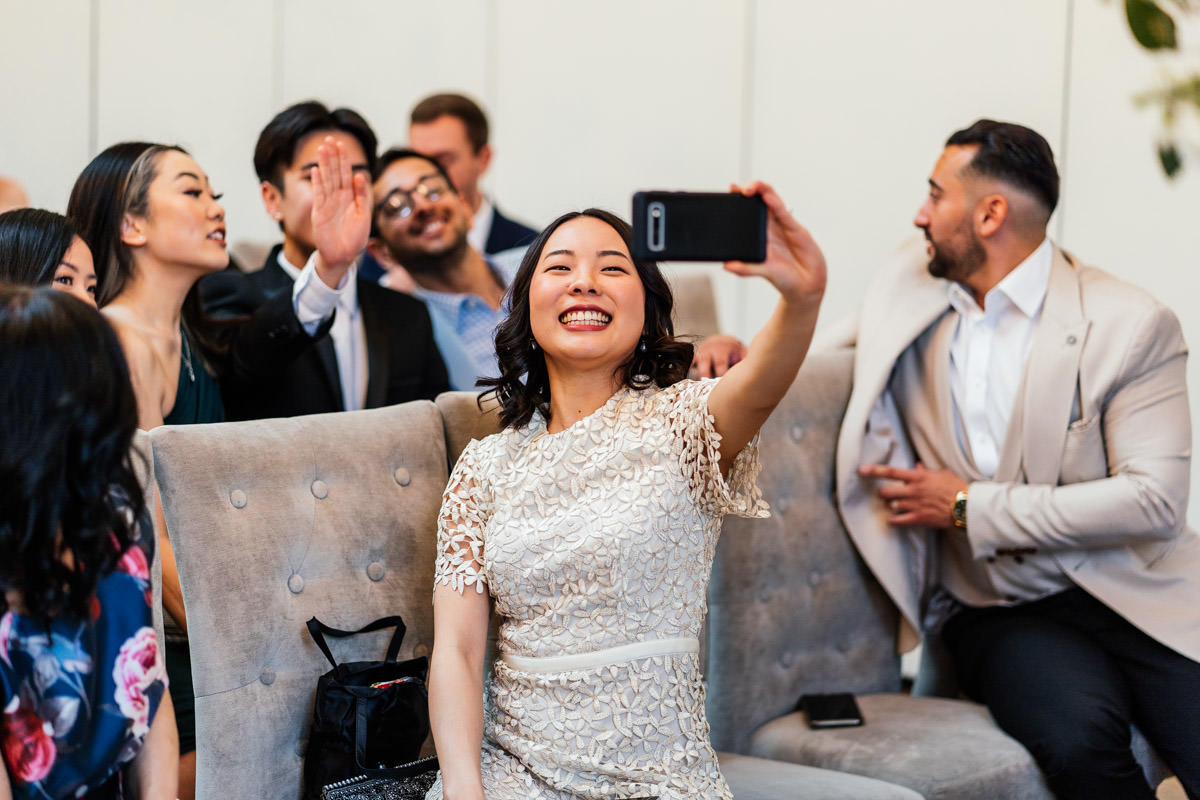 wedding guests taking a selfie just before the ceremony starts