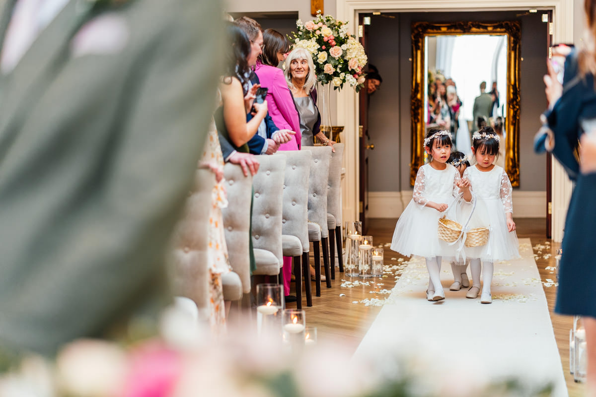 flower girls walking down the aisle sprinkling petals as they walk