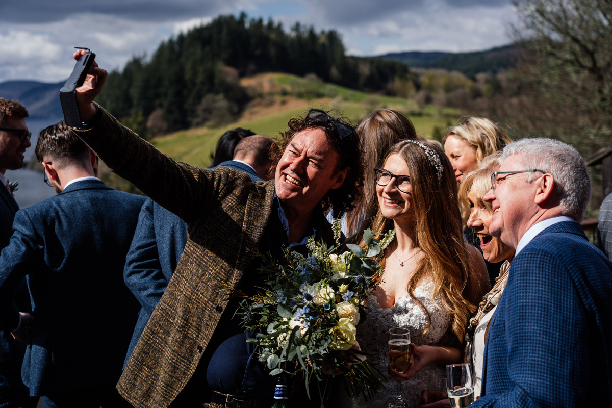 wedding guests take a selfie with the bride during the drinks reception