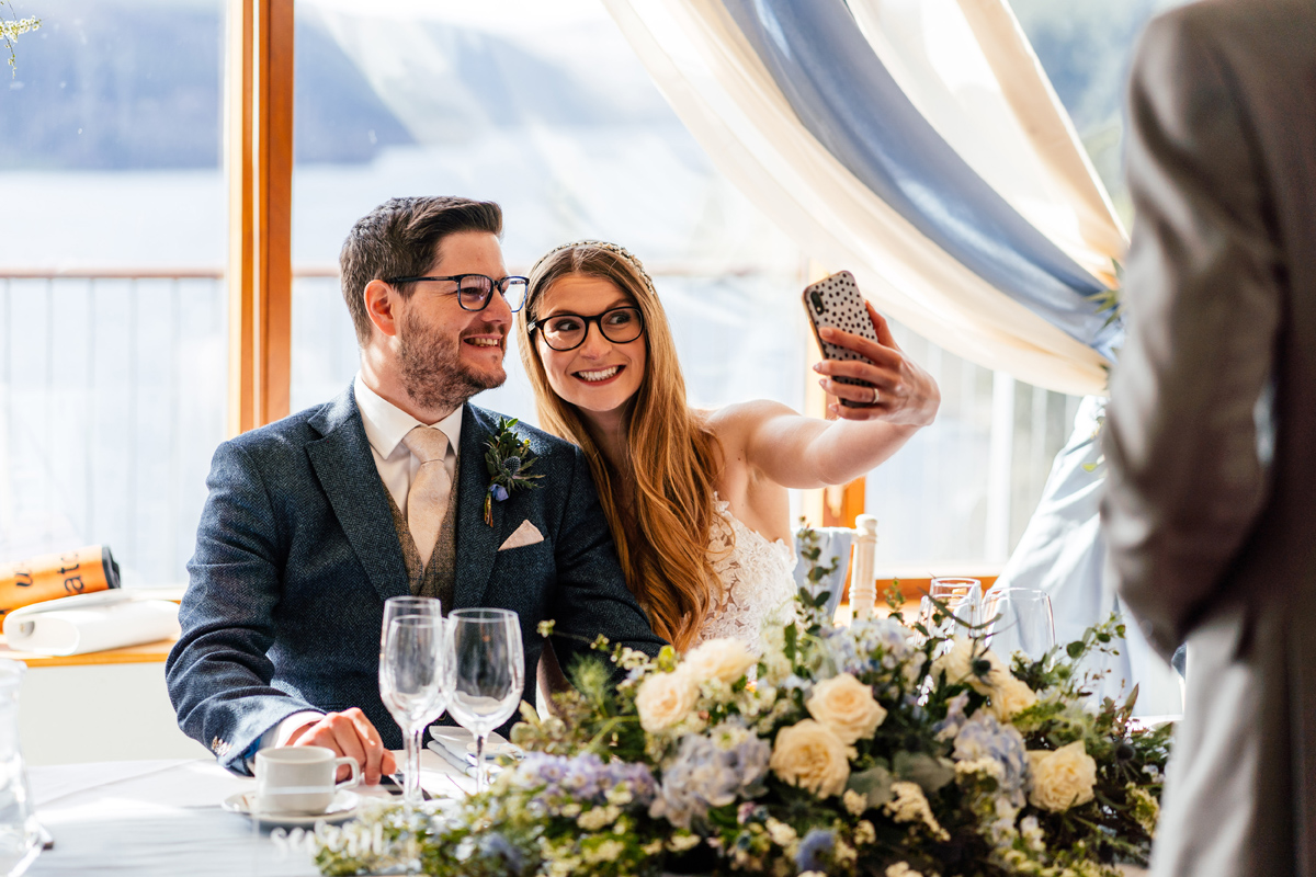 bride and groom take a selfie photo when sitting down at the dinner table