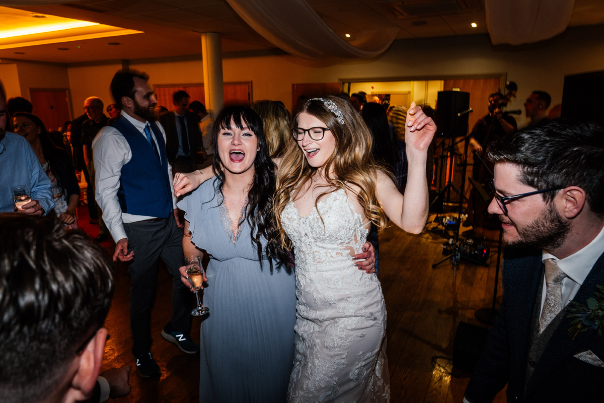 bride and bridesmaid singing and dancing in the evening party