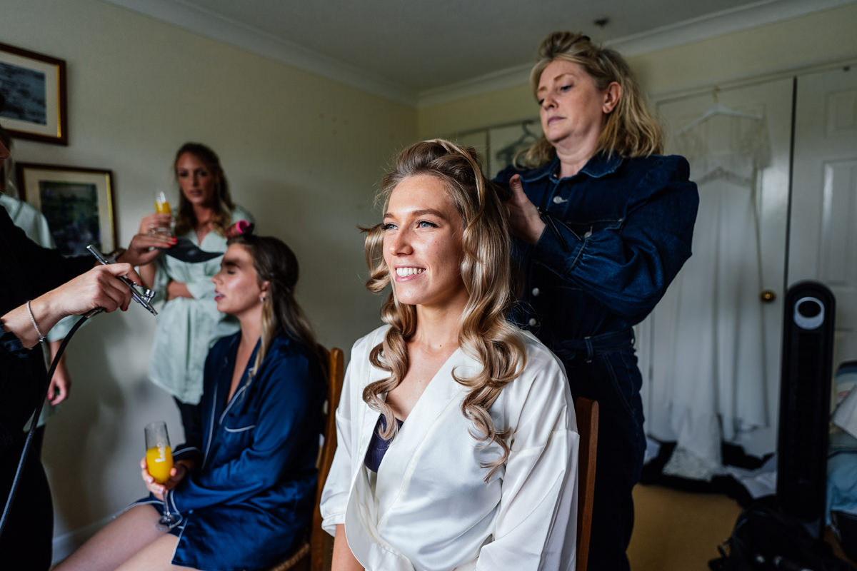 Bride getting her hair done in the morning of her wedding day