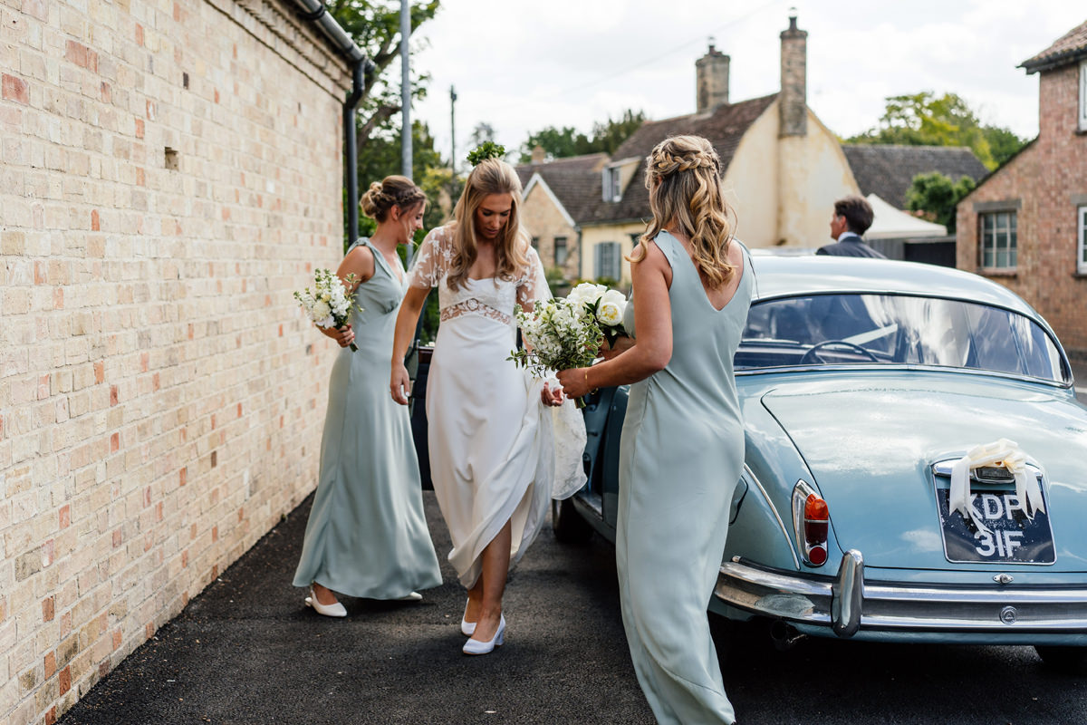 Bride arrives at church in a vintage blue jaguar car