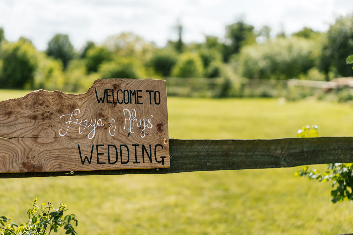 signage on the gate to a field welcoming guests to the wedding