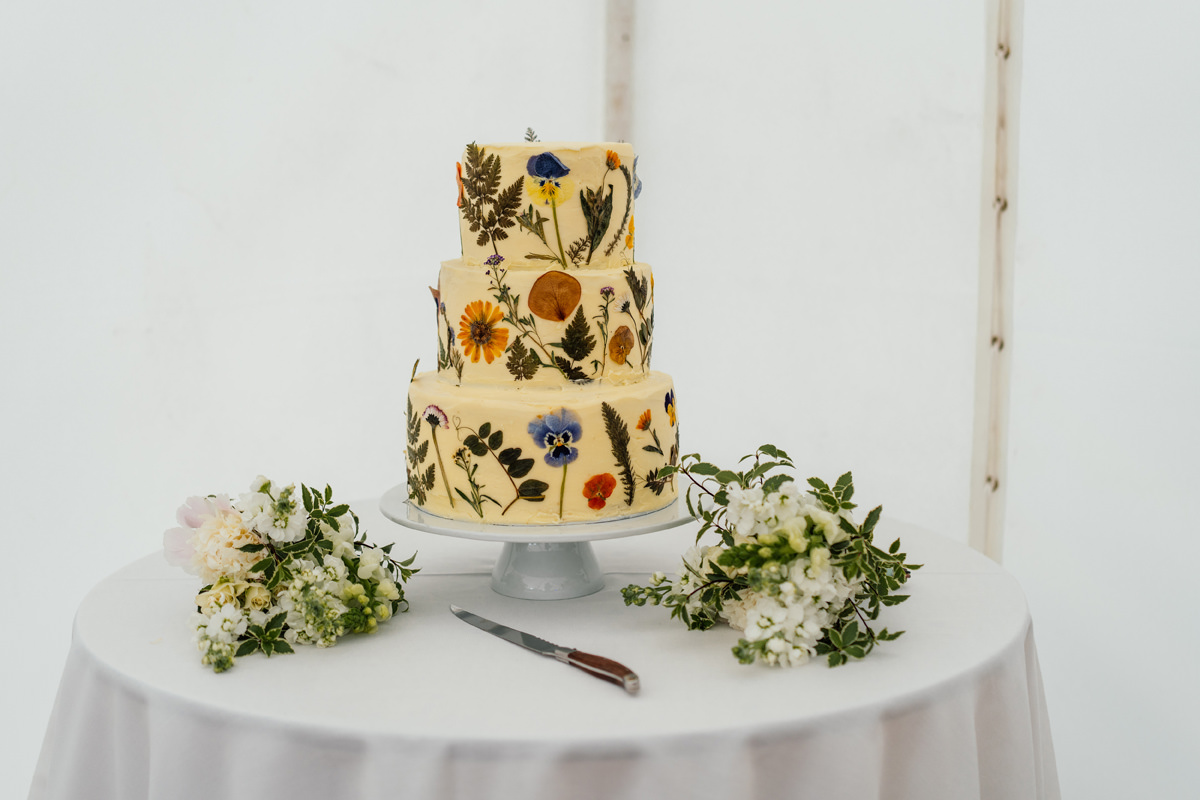 wedding cake with flowers and petals around the outside