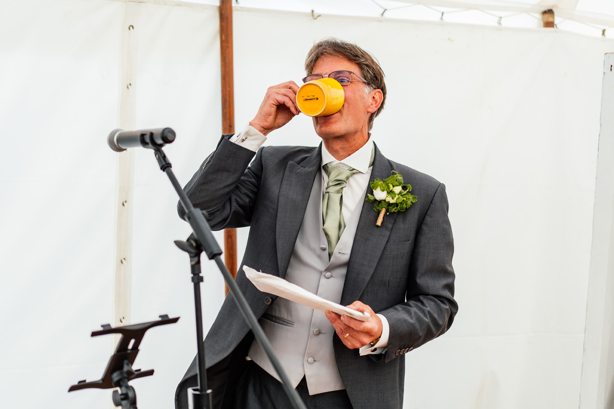 father of the bride giving his speech and drinking a mug of tea