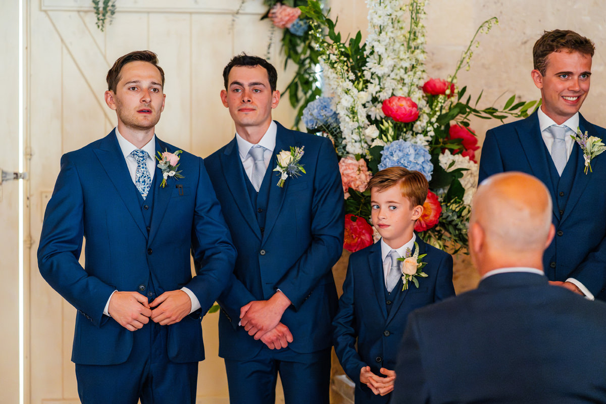 Groom with his groomsmen waiting for the bride and bridesmaids to arrive at the ceremony barn